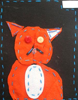 Orange cat sewn out of felt with button eyes